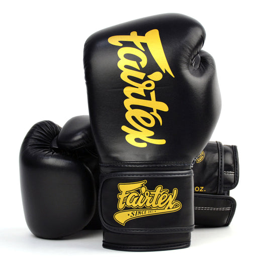 Black boxing gloves with gold 'Fairtex' branding on a white background