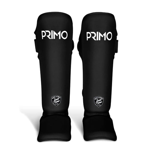 Black shin guards with 'Primo' branding on a light gray background