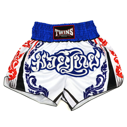 White boxing shorts with blue and red patterns and Twins Special logo on a white background