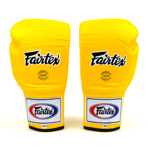 Pair of yellow Fairtex boxing gloves on a white background