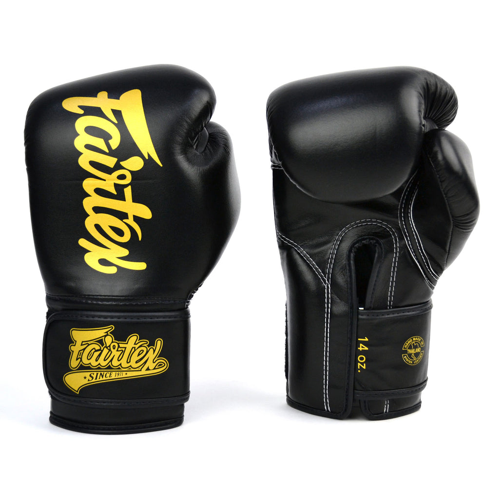 Black boxing gloves with gold 'Fairtex' branding on a white background