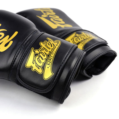Black boxing gloves with gold 'Fairtex' branding on a white background