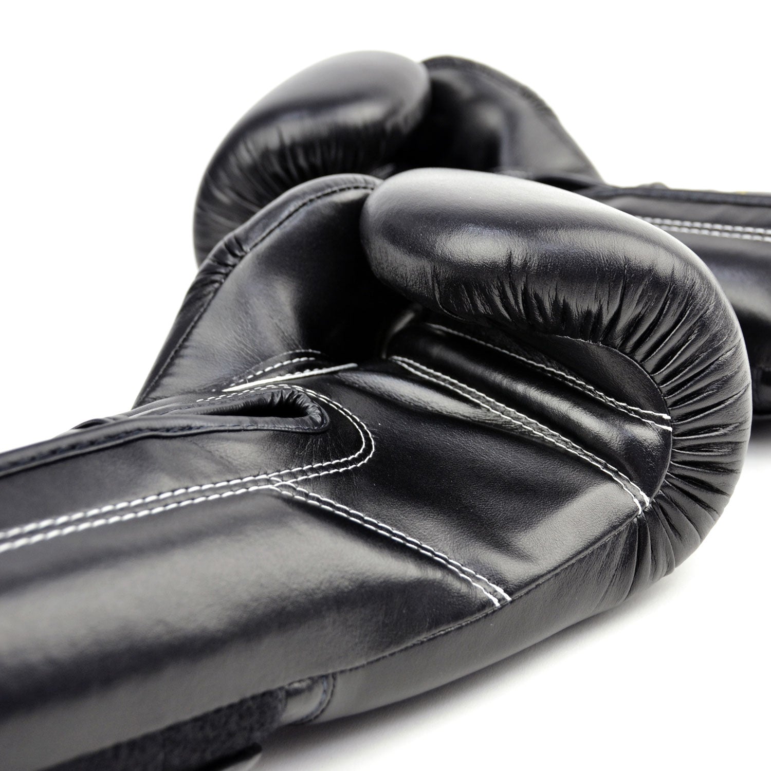 Black boxing gloves with gold 'Fairtex' branding on a white background