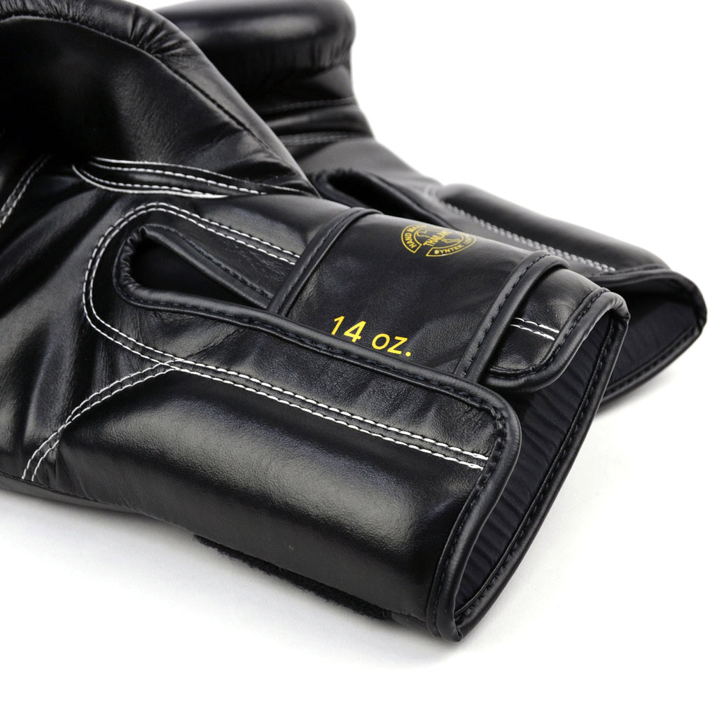 Black boxing gloves with gold 'Fairtex' branding on a white background