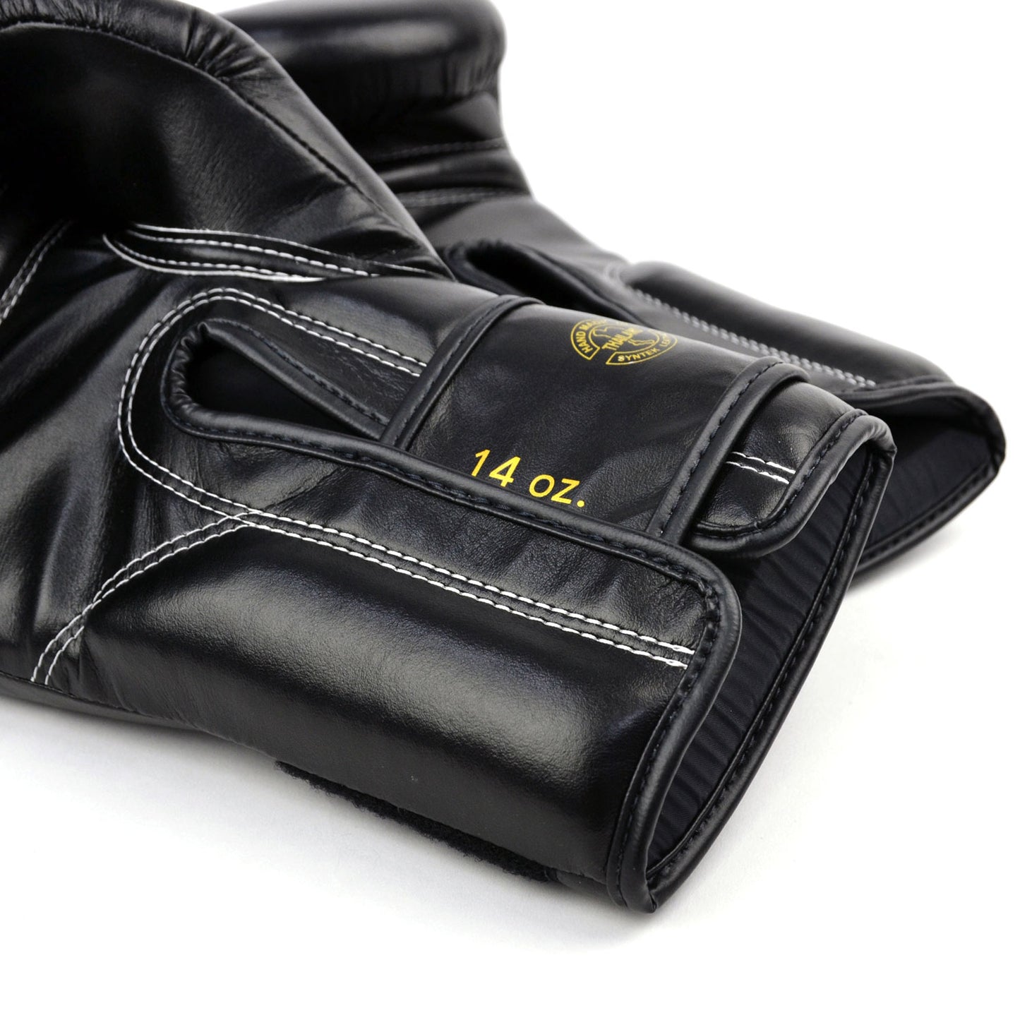Black boxing gloves with gold 'Fairtex' branding on a white background