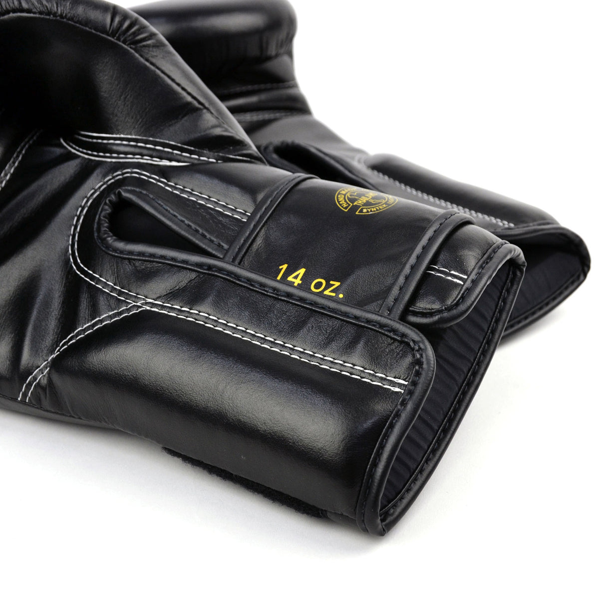 Black boxing gloves with gold 'Fairtex' branding on a white background