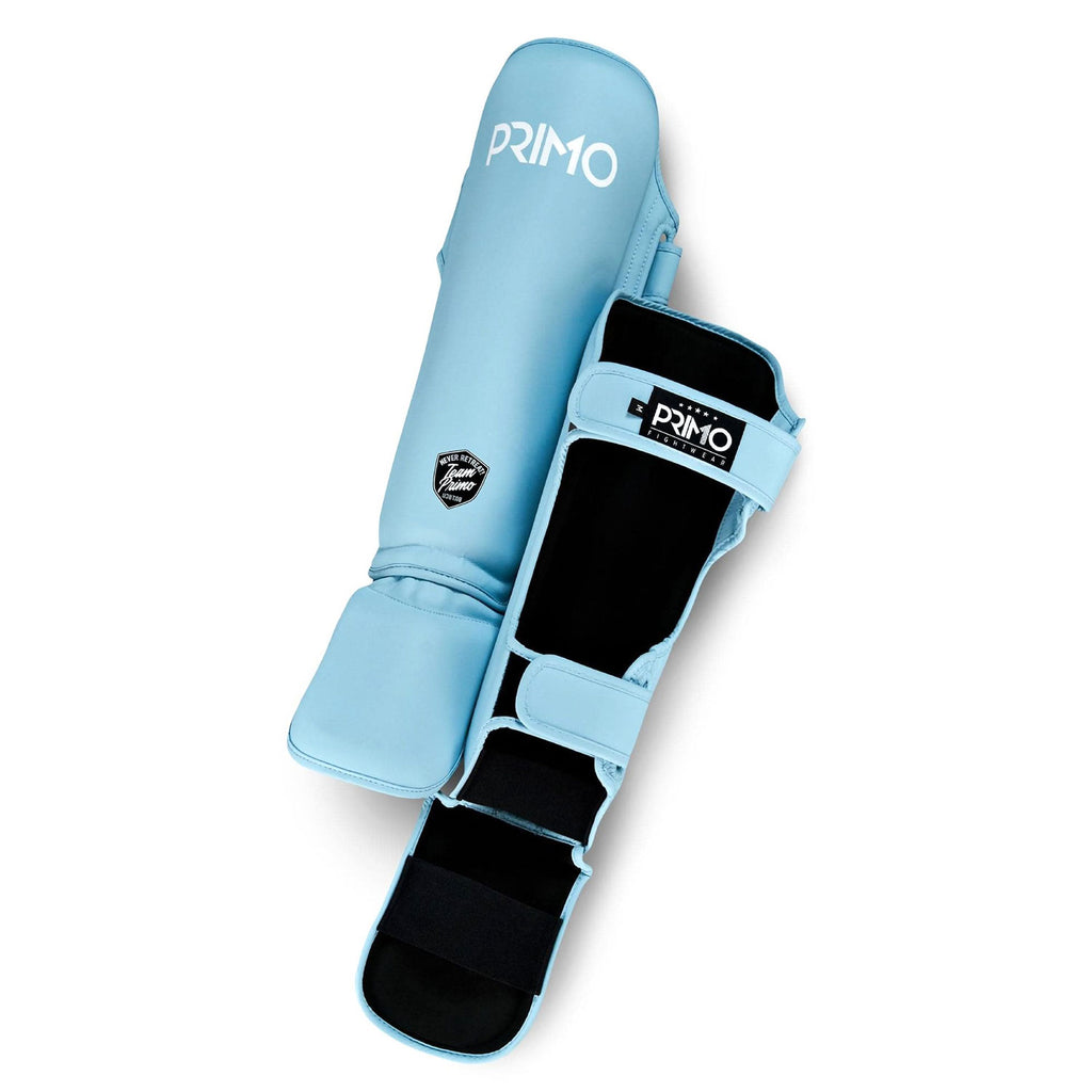 Light blue shin guards with black accents on a white background, featuring the 'Primo' brand.