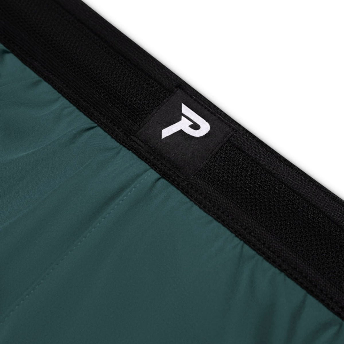 Close-up of a teal bag with a black strap and logo on a white background