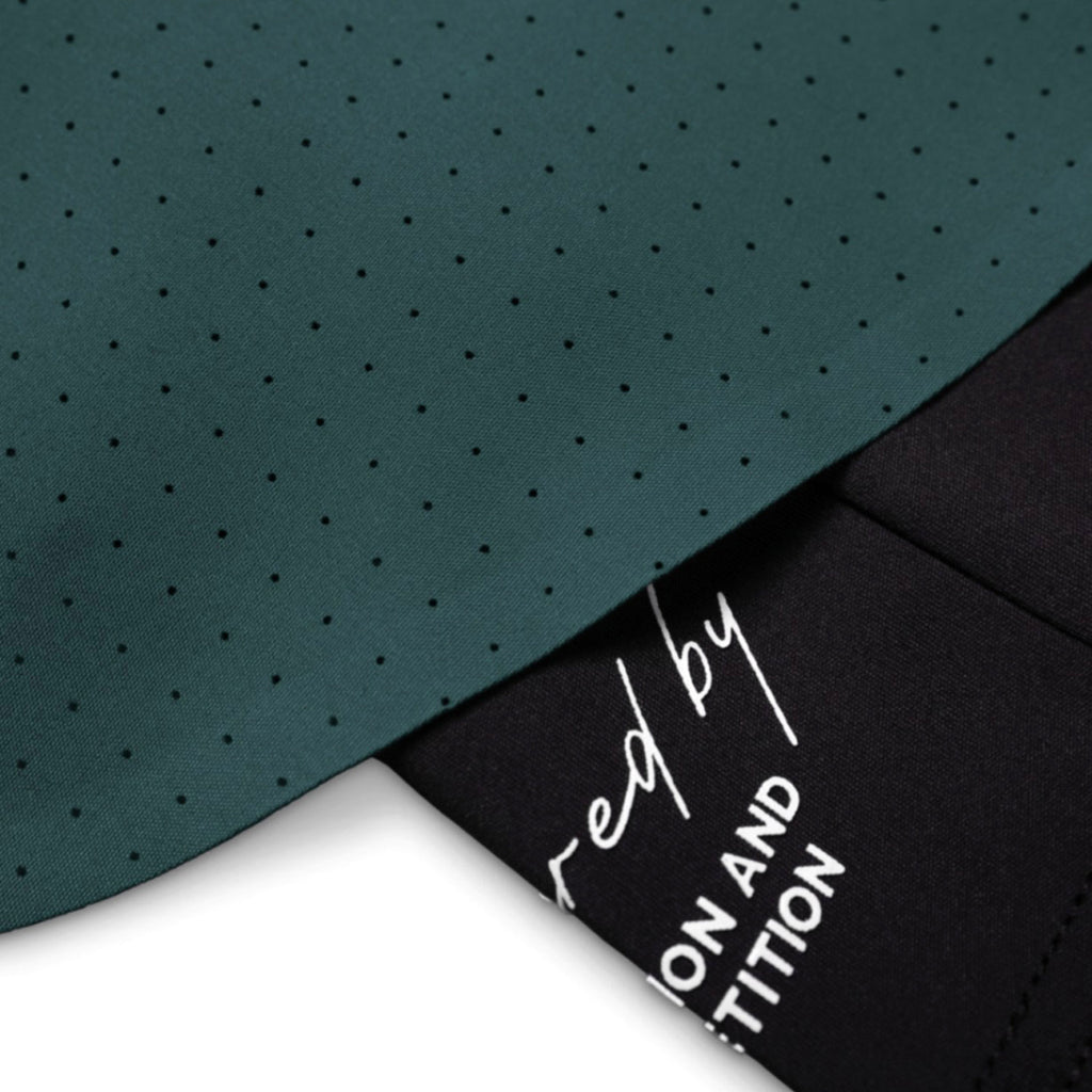 Teal fabric with a subtle pattern and black fabric with white text on a white background