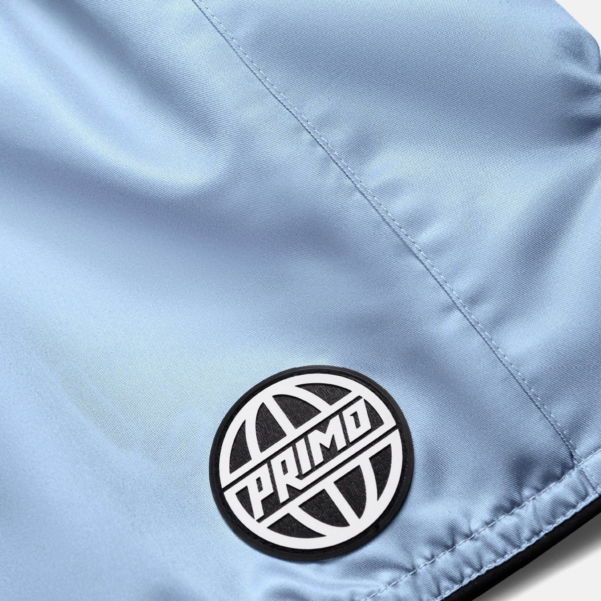 Close-up of a light blue fabric with a 'Primo' logo patch.