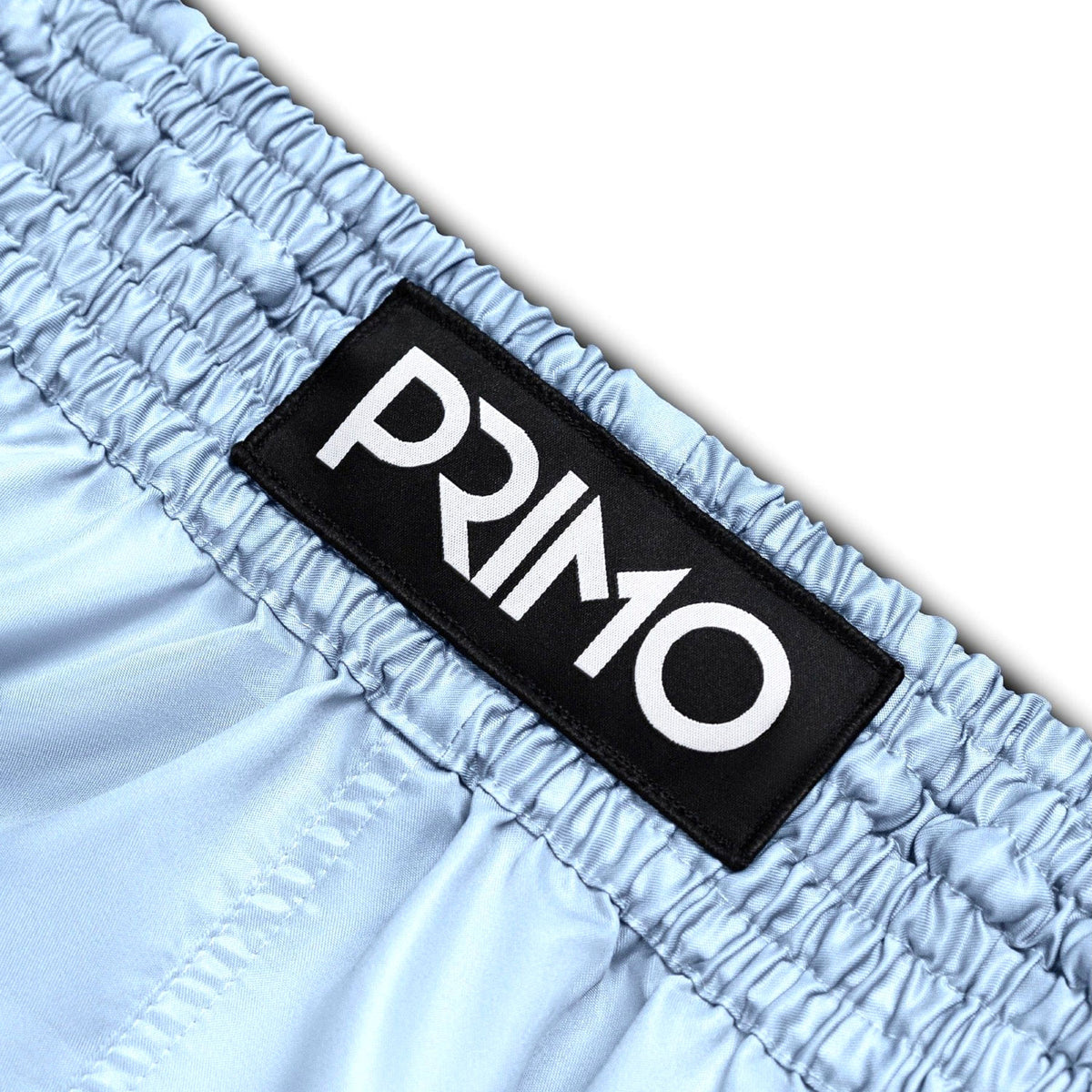 Light blue shorts with a black 'Primo' logo patch on a white background