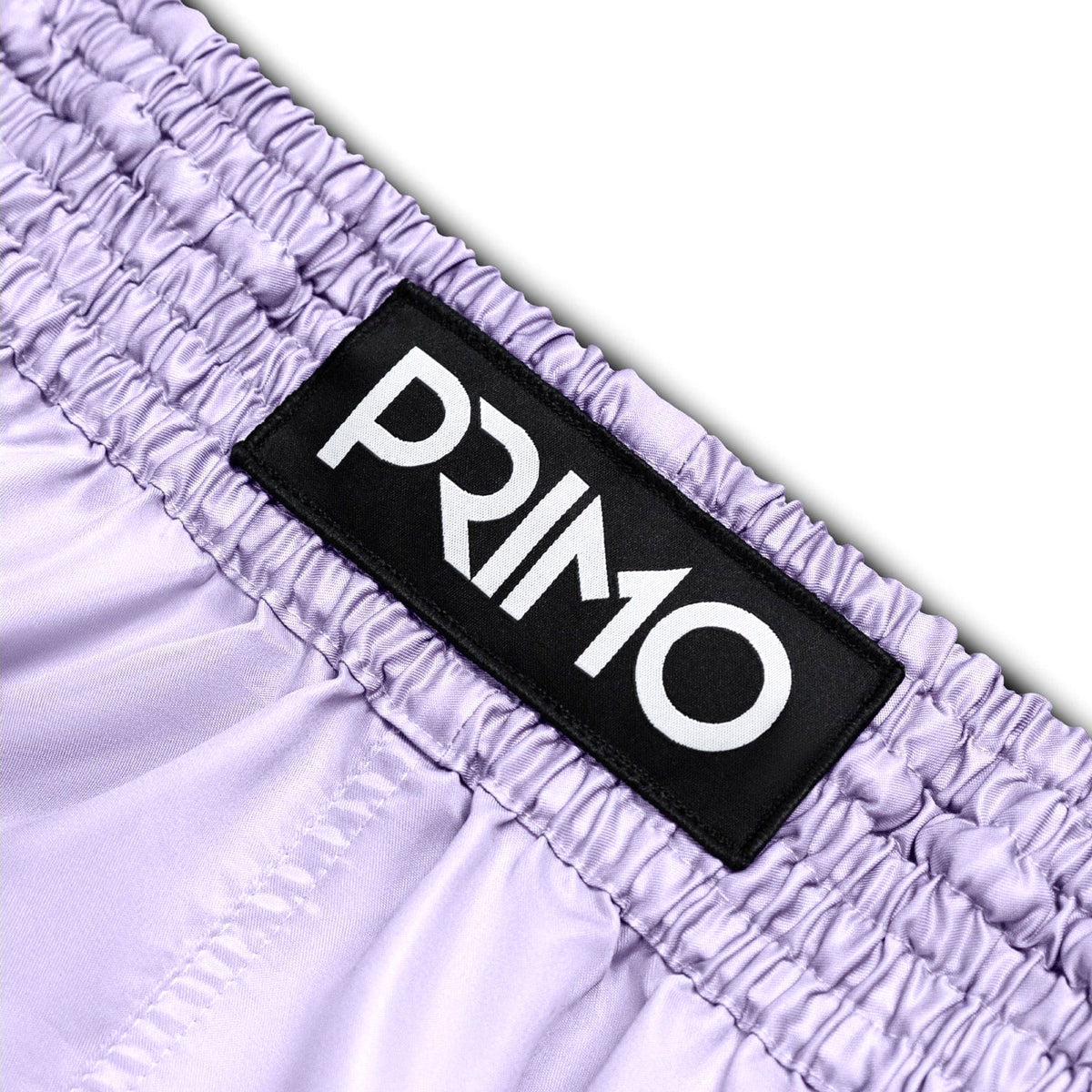 Close-up of a purple garment with a 'Primo' label on a white background