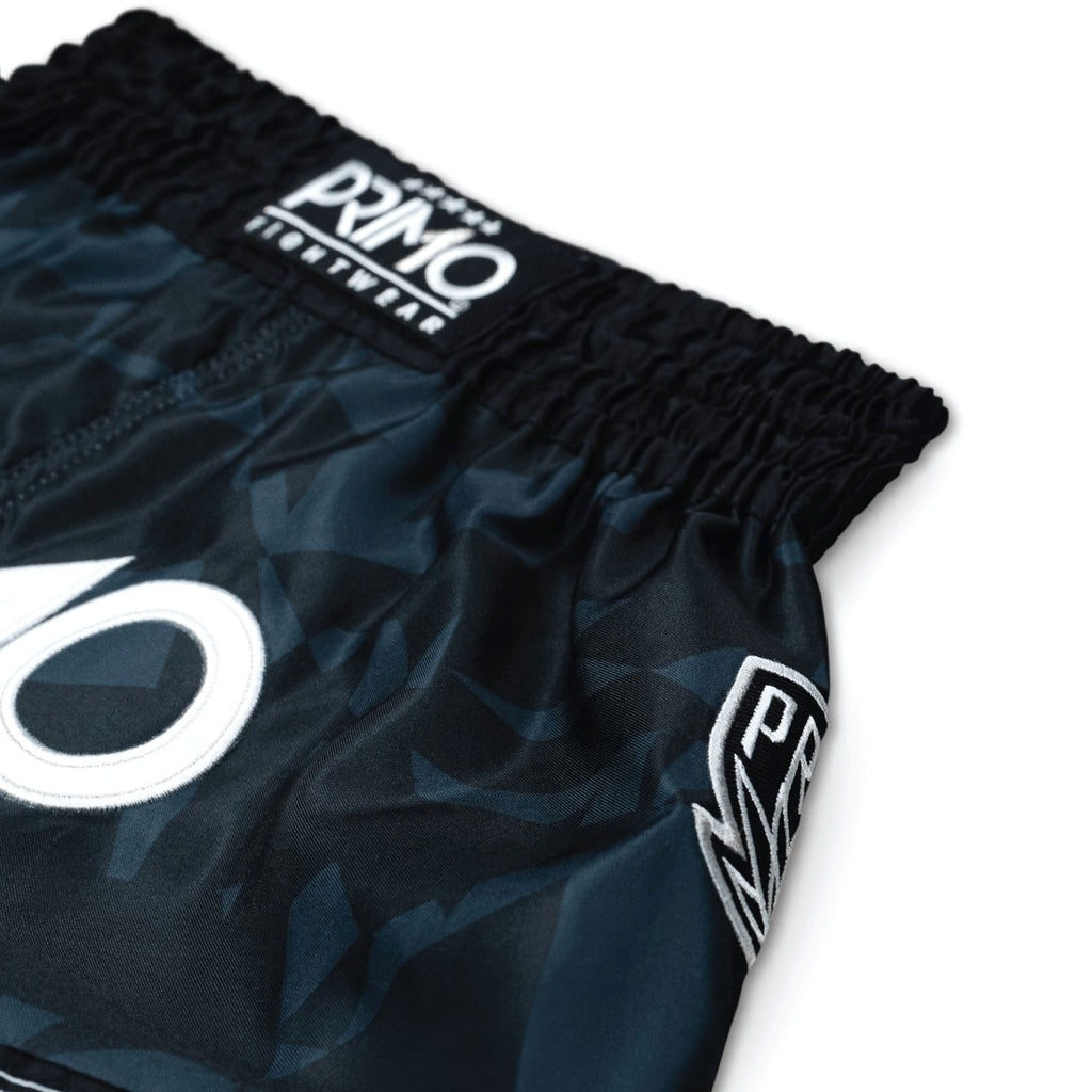 Black athletic shorts with white branding on a white background