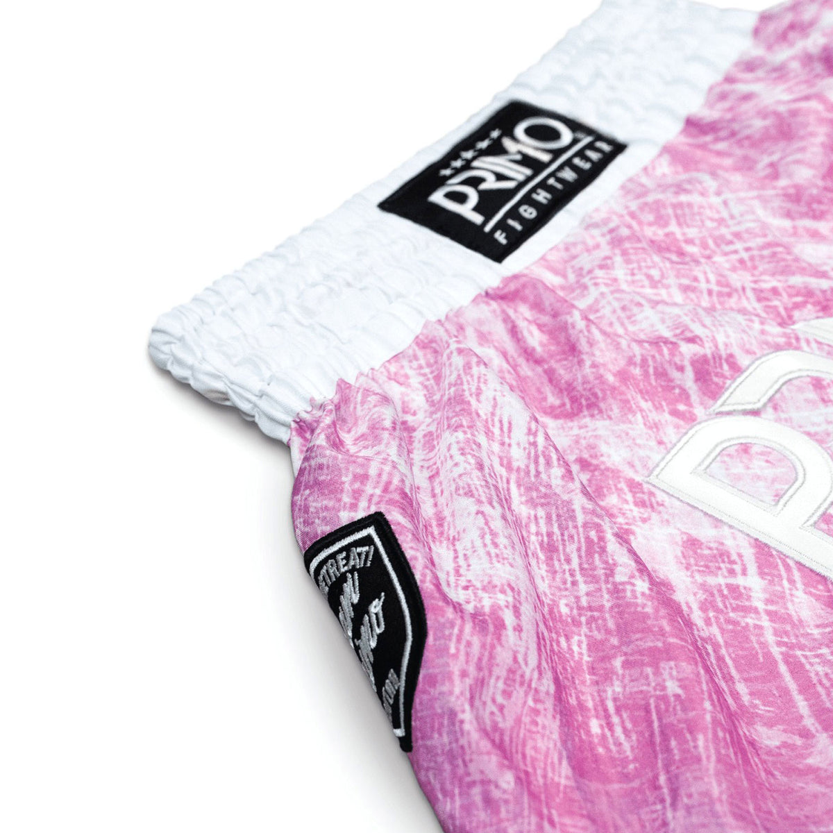 Close-up of pink and white shorts with a brand logo on a white background