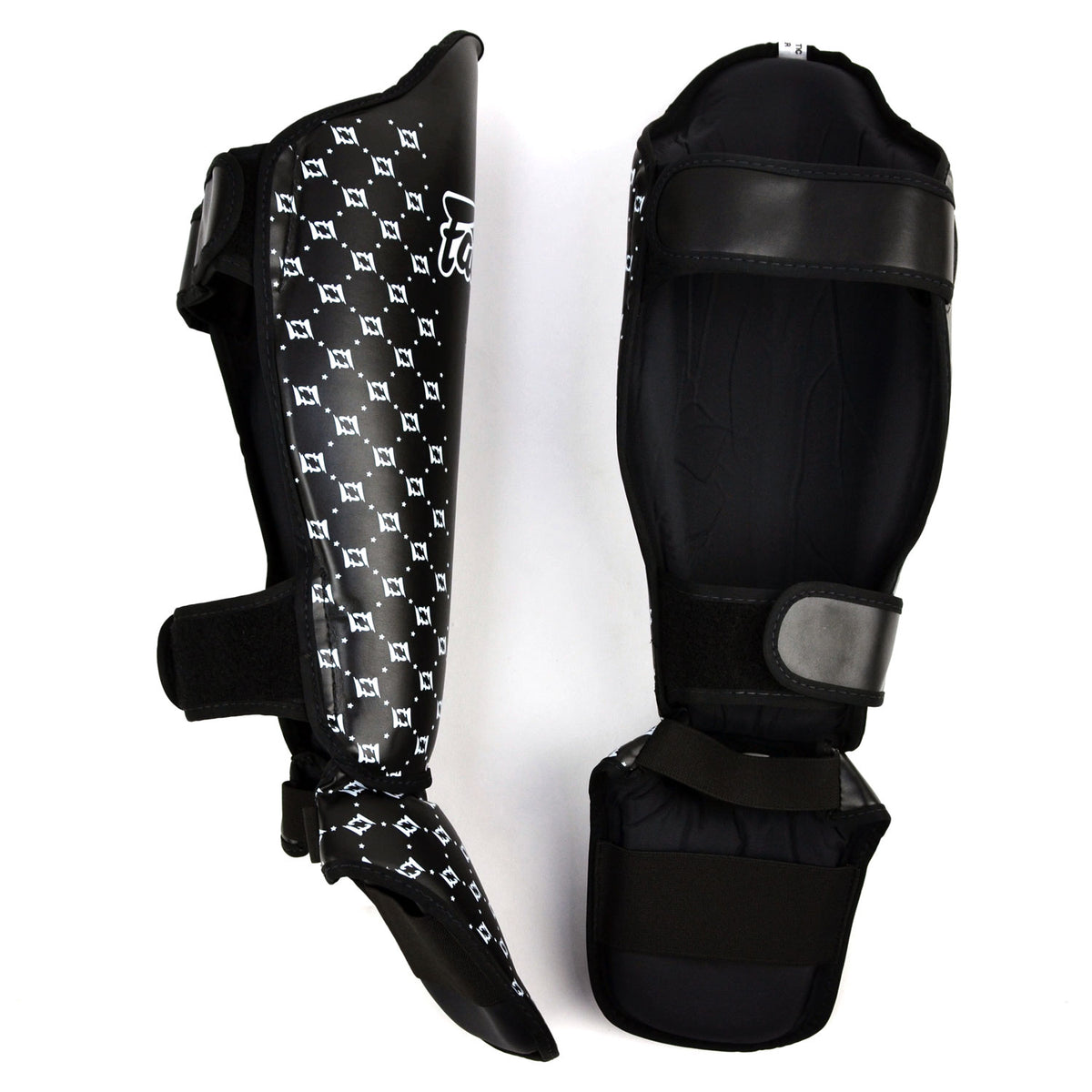 Black shin guards with white pattern and 'Fairtex' branding on a white background
