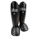 Black shin guards with white pattern and 'Fairtex' branding on a white background
