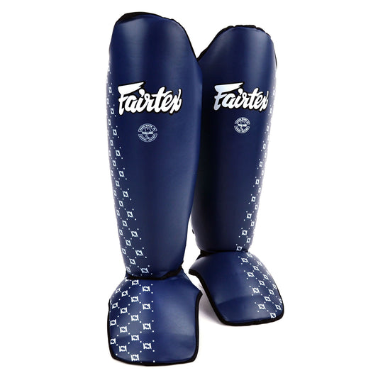 Pair of blue Fairtex shin guards with white patterns on a white background