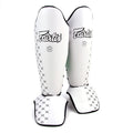 Pair of white shin guards with black patterns and 'Fairtex' branding on a white background