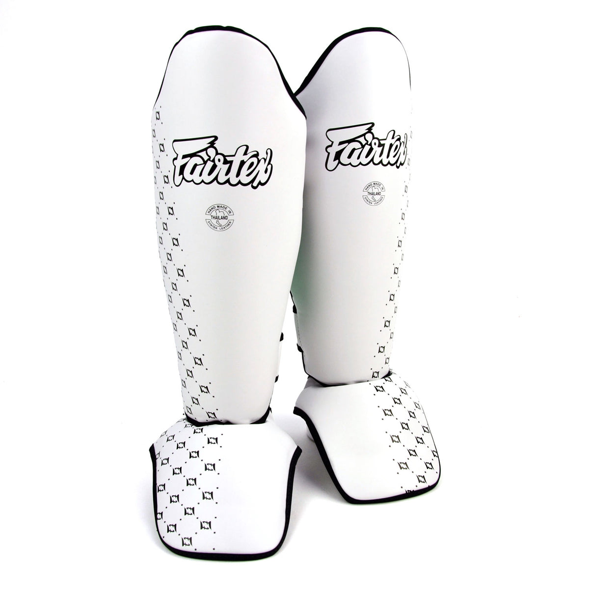 Pair of white shin guards with black patterns and 'Fairtex' branding on a white background
