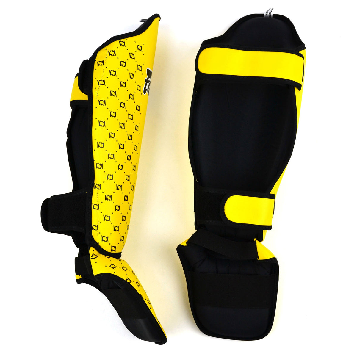 Yellow shin guards with Fairtex logo on a white background