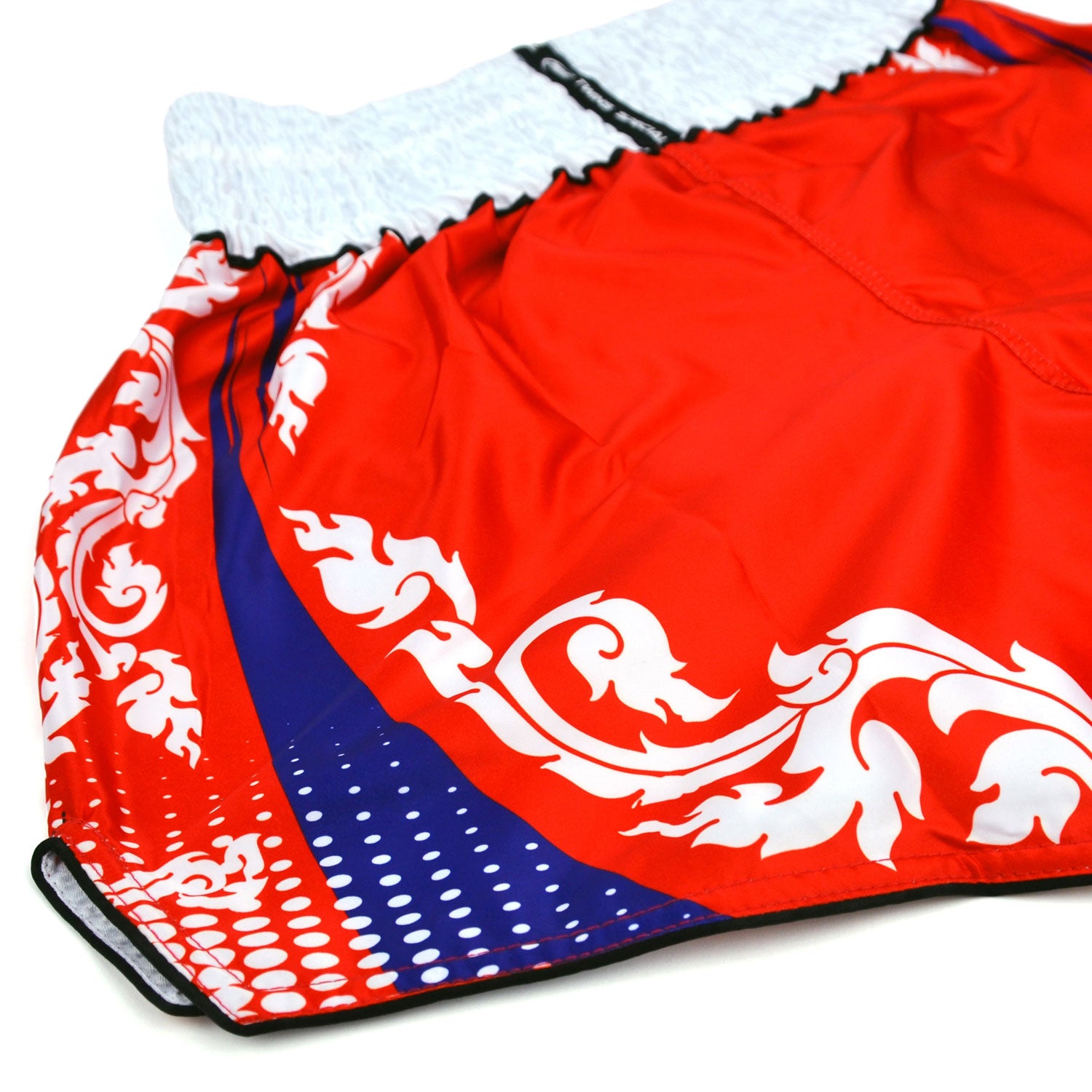 Red boxing shorts with white and blue patterns and 'Twins' branding on a white background